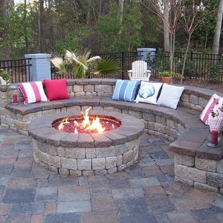 Outdoor fire pit with stone bench and pillows